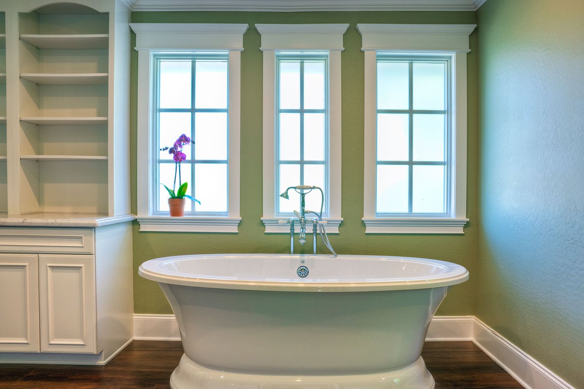 Stand alone tub with green paint on the walls