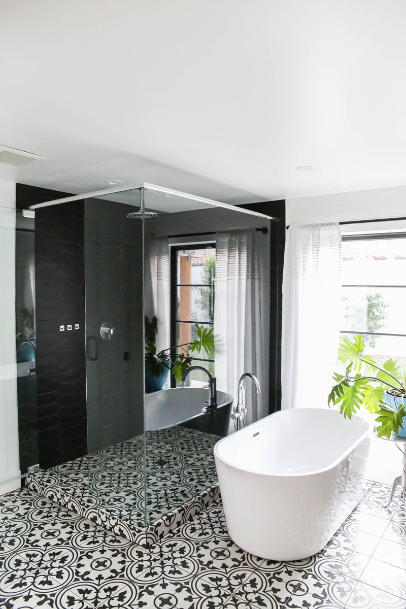 Stand alone tub and walk in shower with black tile