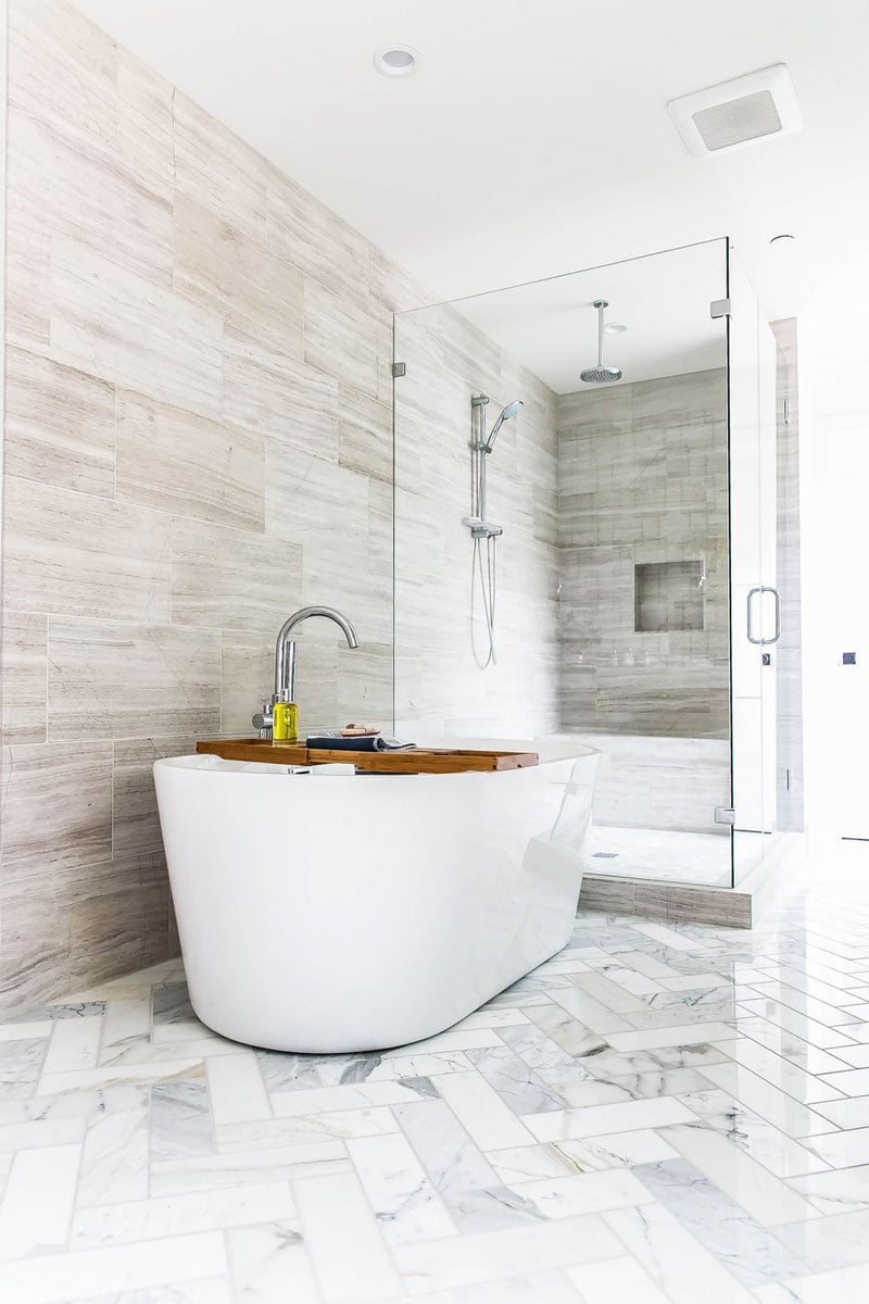 stand alone tub on white diagonal bathroom tiles
