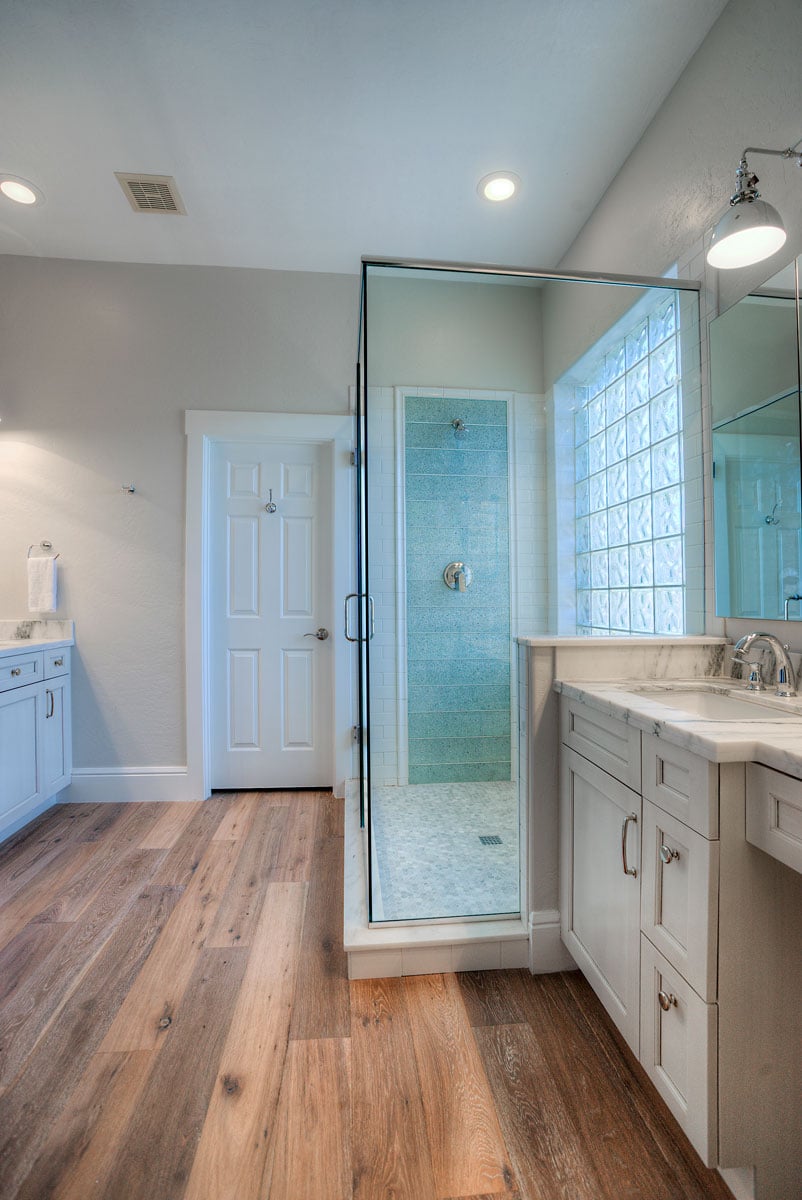 wide angle view of master bathroom with hardwood floor and walk in shower