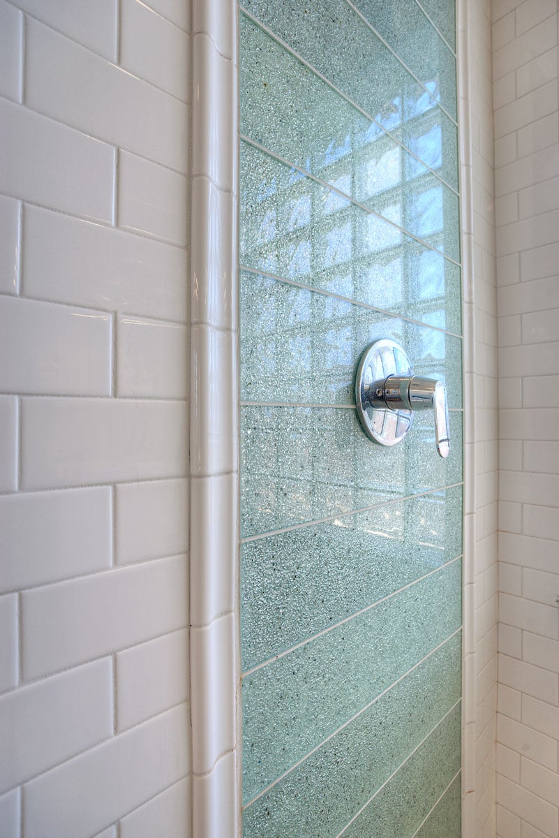 Close up of shower tiling and temperature controlling handle