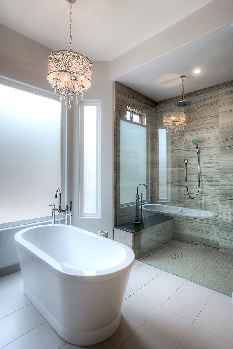 Stand alone master bathtub with chandelier hanging above