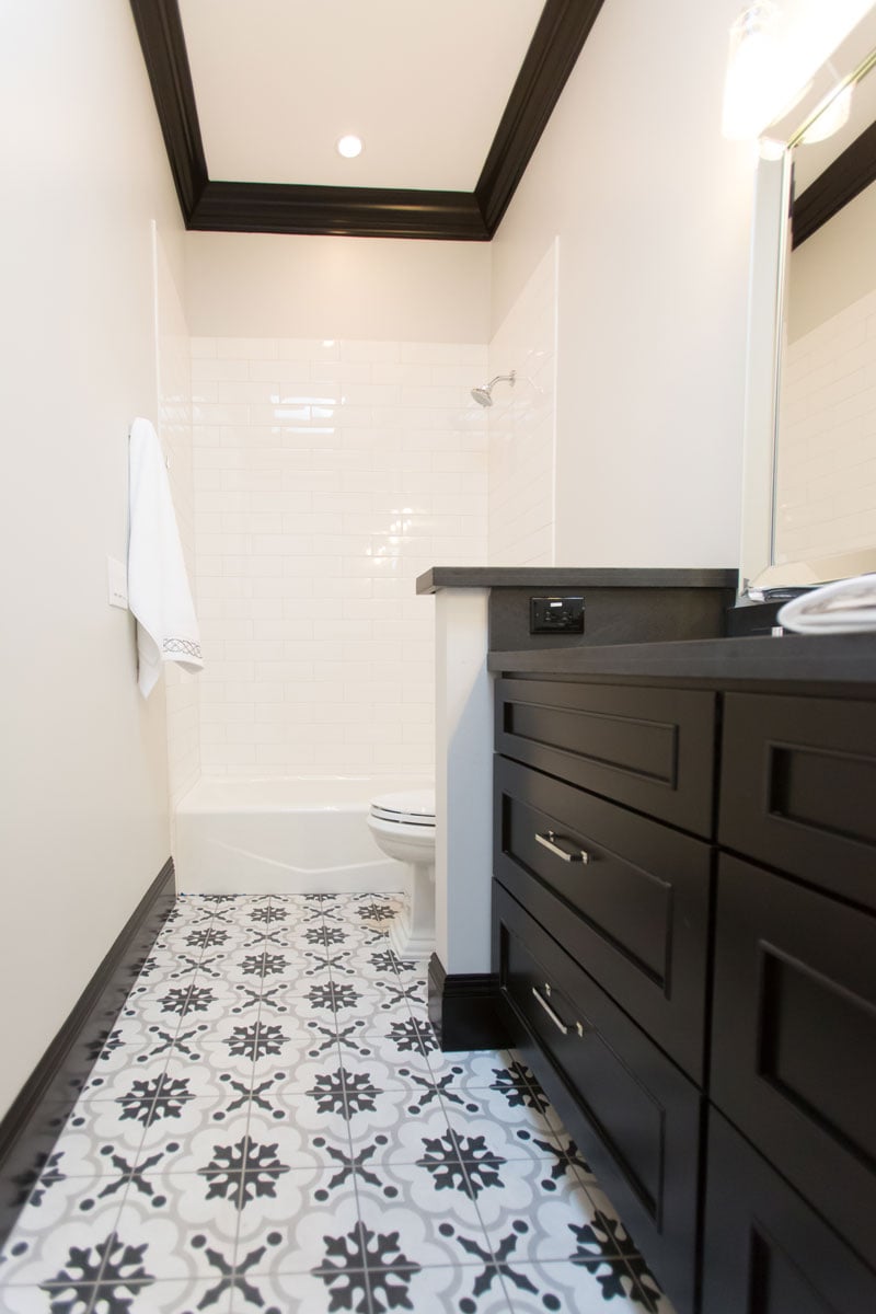 Narrow bathroom with white walls and black decor