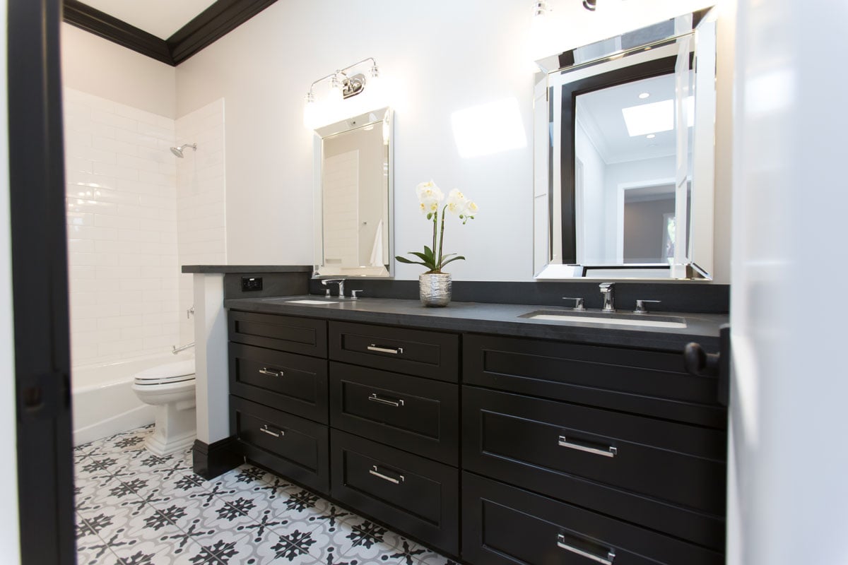 Wide angle of black and white bathroom with printed textile on floor tile