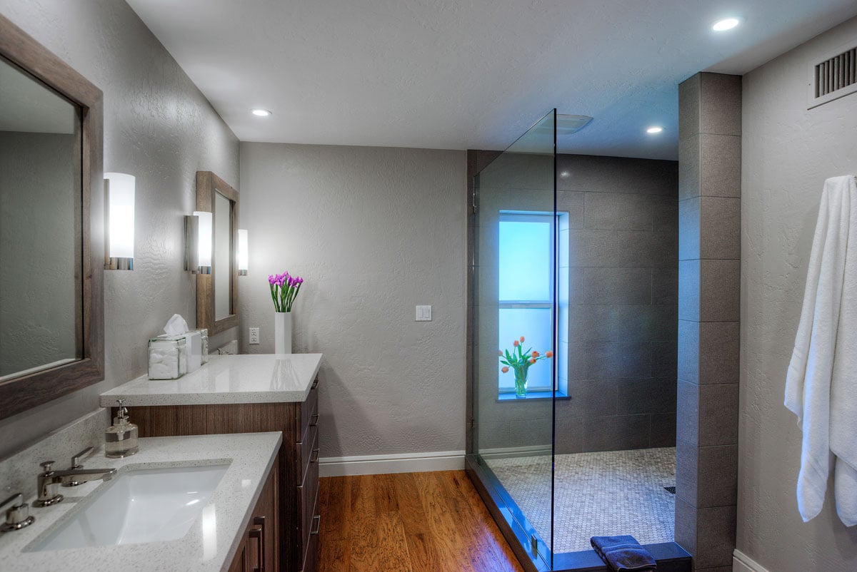 left angle of bathroom vanity with hardwood flooring and glass shower door