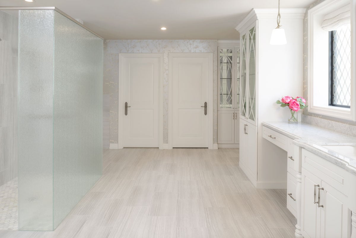 walk in shower with master bathroom entrance and closet doors